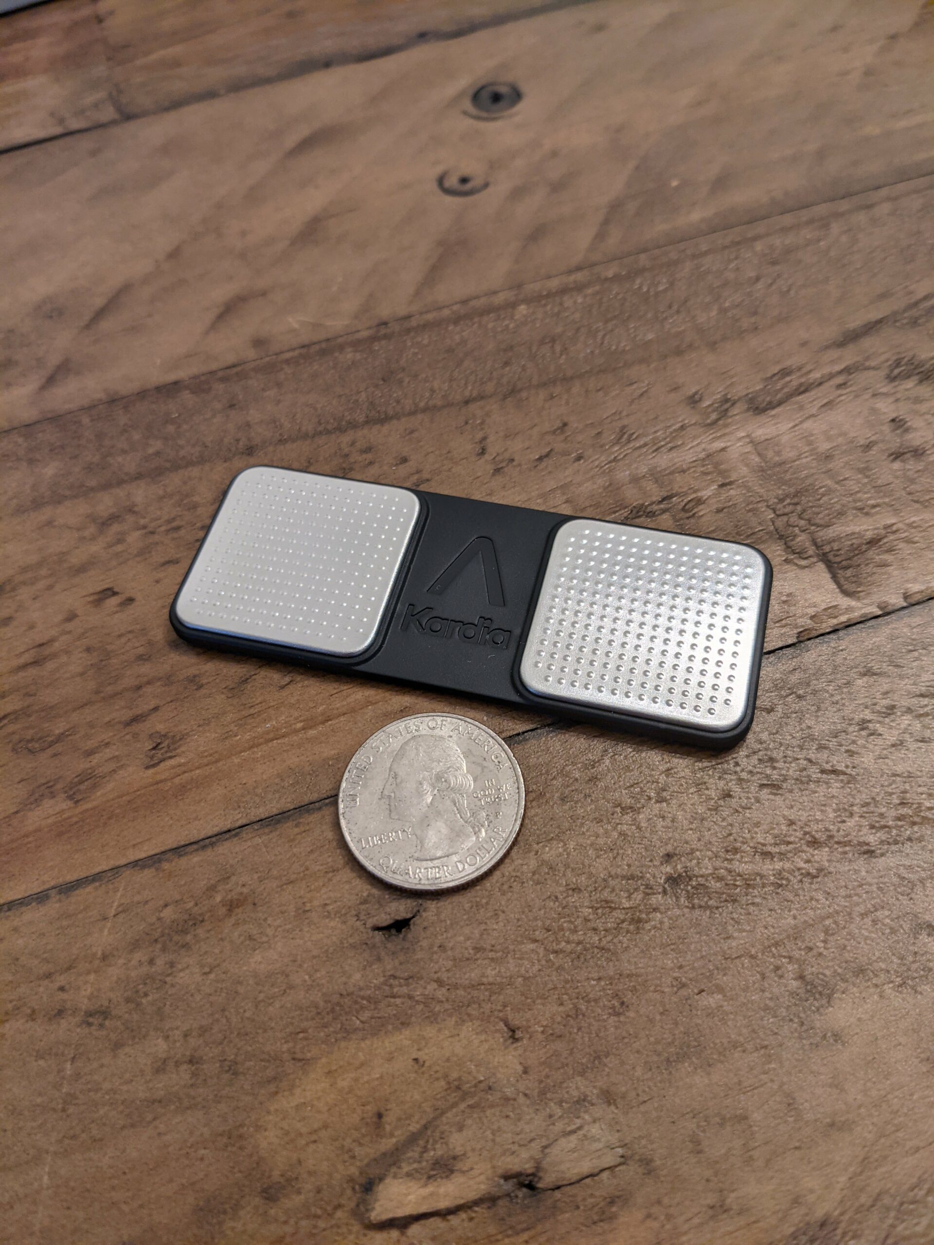 KardiaMobile EKG Monitor with a quarter for size comparison